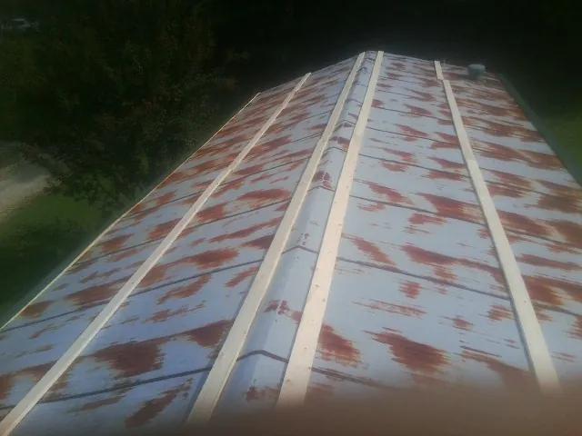 Rusted metal roof panels with new wood purlins before replacement — Storm Damage Roof Repair in Westfield Center by Roofing Brothers