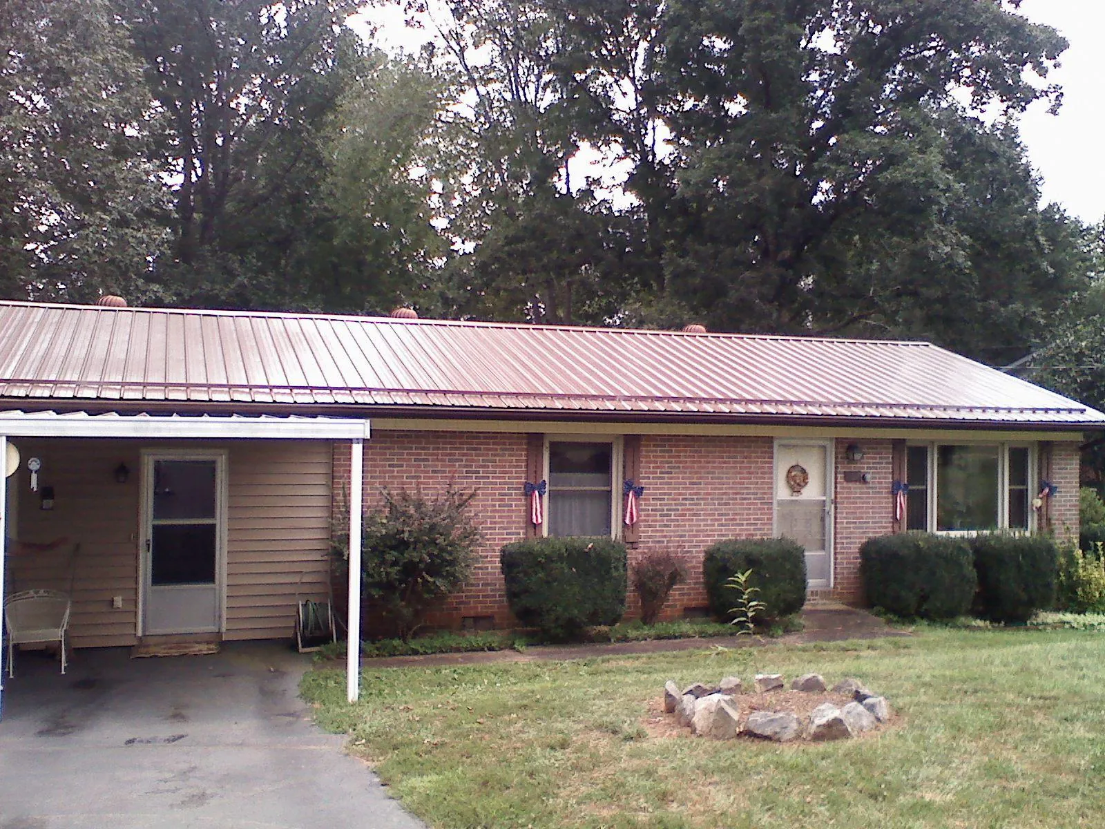 Bronze metal roof and carport on a brick ranch home — Roof Repair work by our crew in Westfield Center